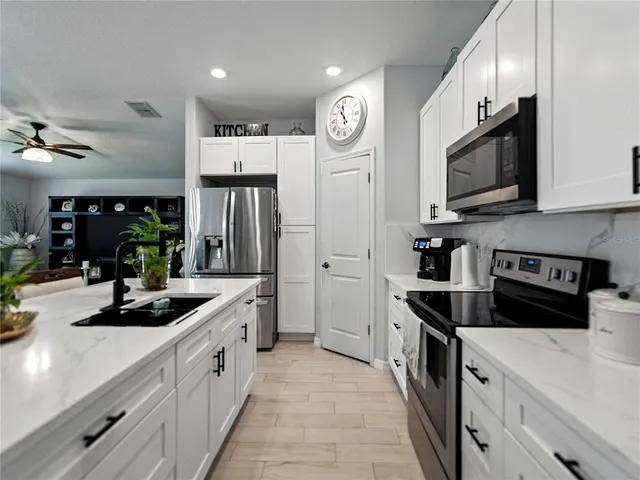 a kitchen with stainless steel appliances a sink stove and refrigerator