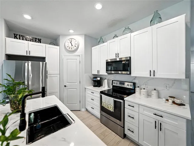 a kitchen with stainless steel appliances a stove microwave and refrigerator