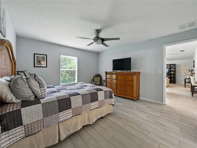 a bedroom with bed and a flat tv screen on dresser