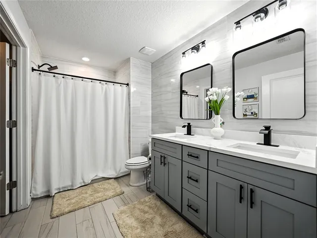 a spacious bathroom with a double vanity sink and mirror