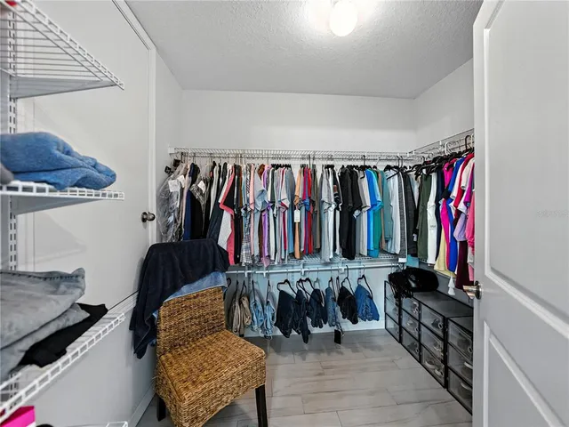 a view of walk in closet with clothes and shoes