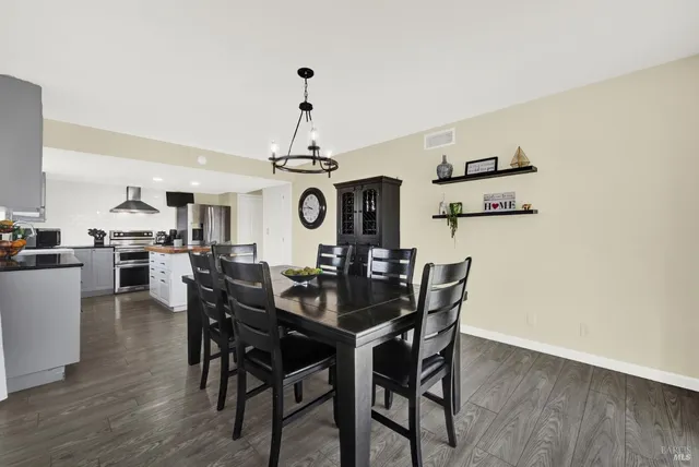 a view of a kitchen with refrigerator and wooden floor