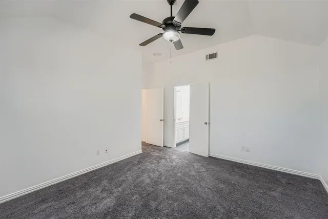 an empty room with a ceiling fan and a window