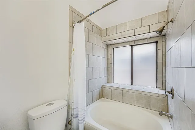 a bathroom with a toilet and shower
