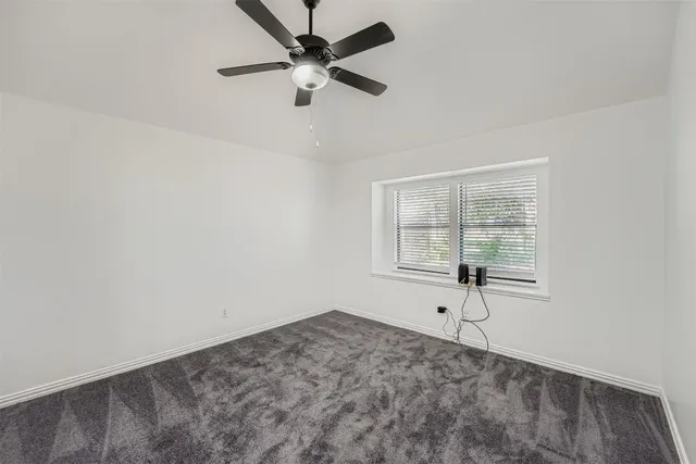a view of a livingroom with a ceiling fan and window