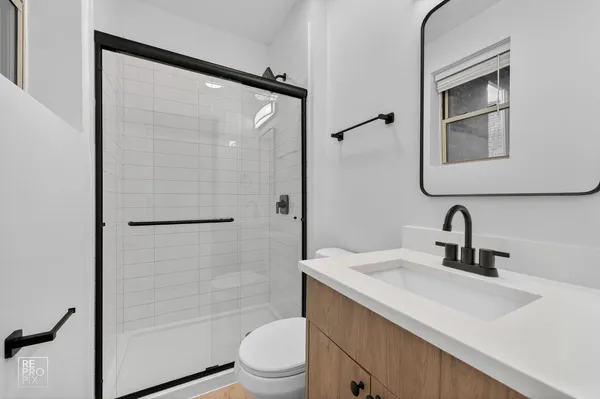 a bathroom with a sink a toilet and shower