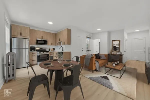 a living room with furniture a refrigerator and a dining table