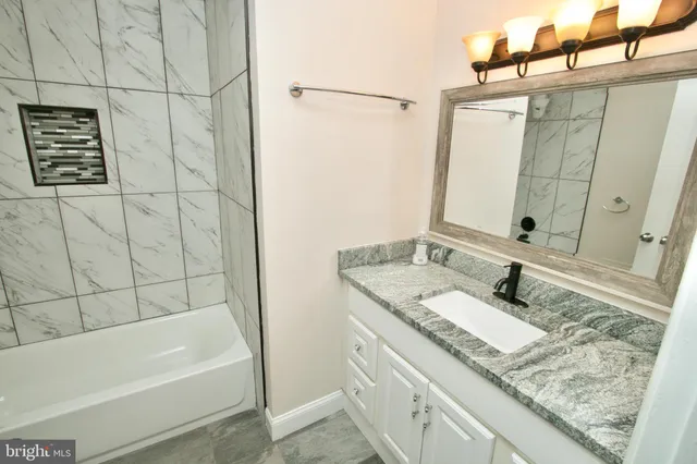 a bathroom with a granite countertop sink and a mirror