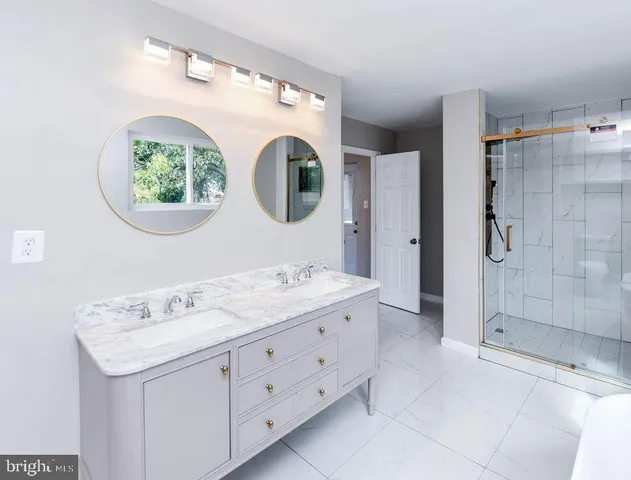 a bathroom with a granite countertop sink and a bathtub