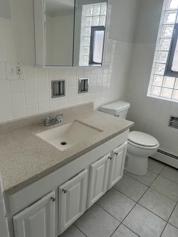 a bathroom with a granite countertop sink mirror and toilet
