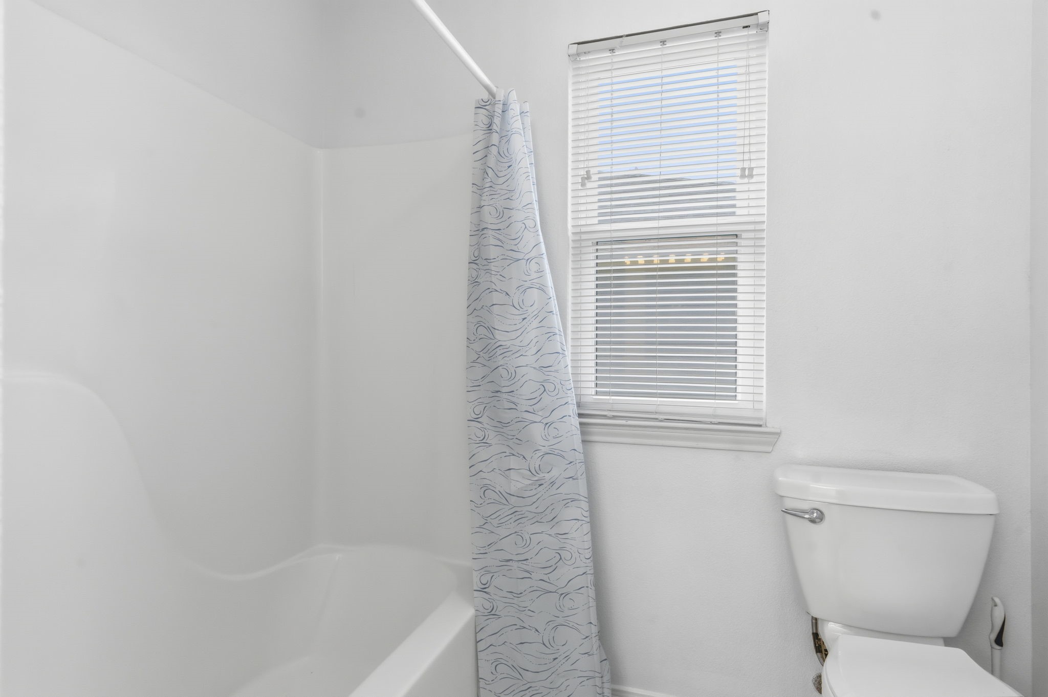 119 Sand Shoals Road Freeport, TX 77541 - Photo 24 of 34 Primary ensuite continued — separate tub/shower combo with full tile surround, private water closet, and natural light from a side window.