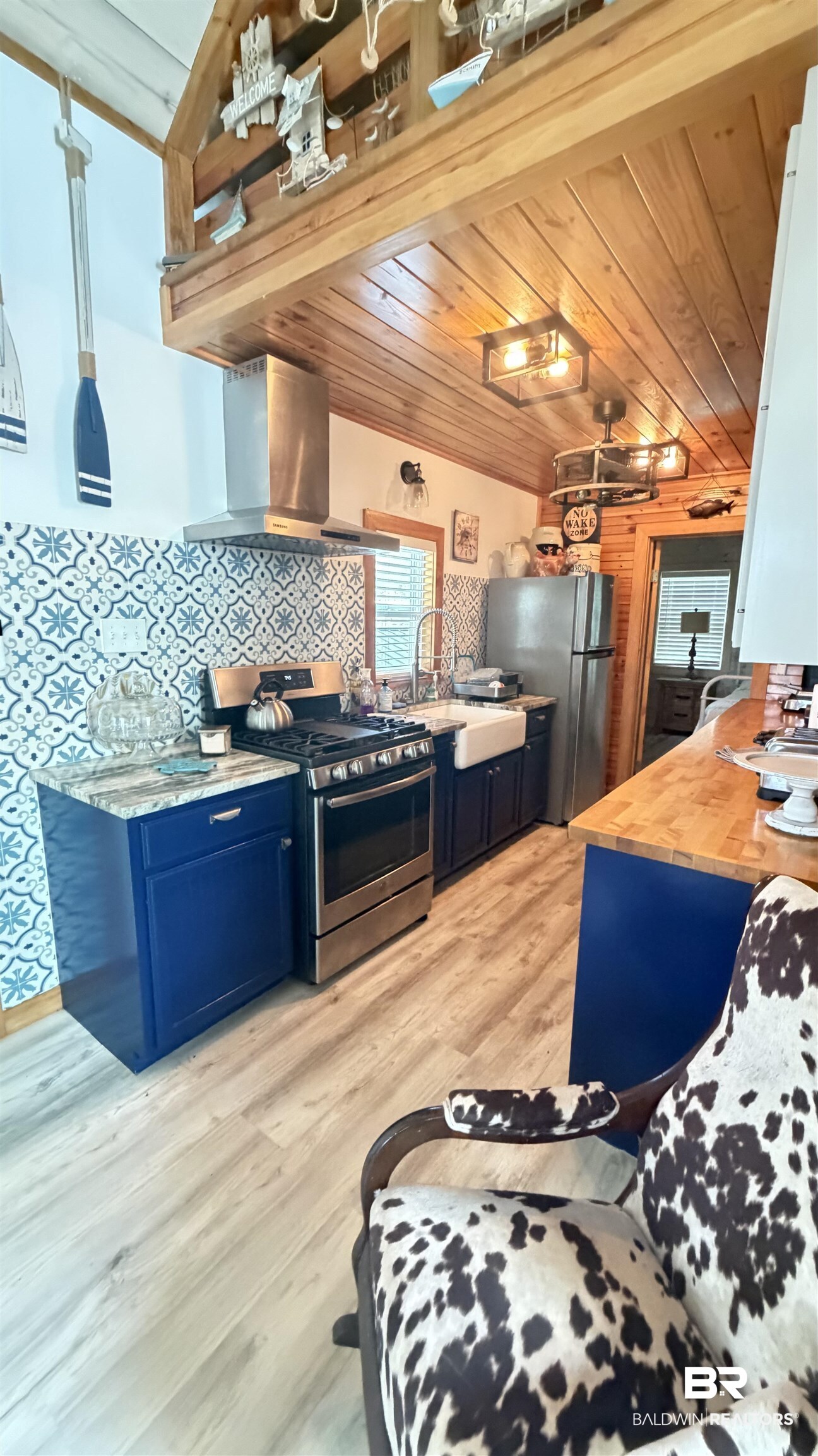 3983 Eureka Landing Road Uriah, AL 36480 - Photo 10 of 45 Kitchen with blue cabinets, stainless steel appliances, light wood-type flooring, wood counters, and wooden ceiling