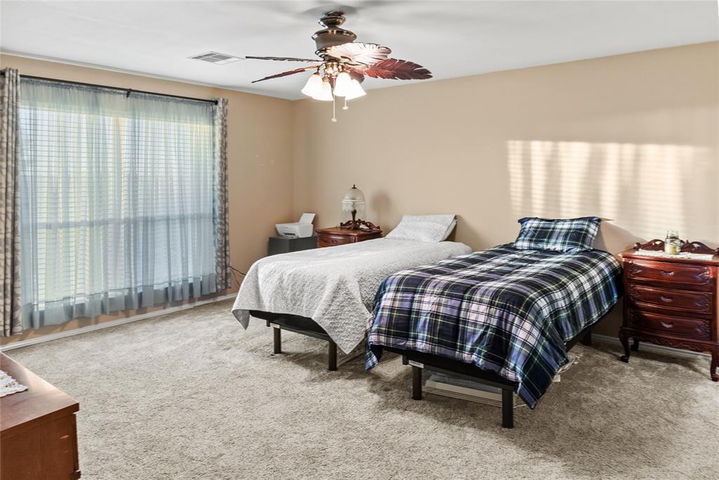 1413 Rodeo Drive Murphy, TX 75094 - Photo 11 of 29 a bedroom with a bed and a chandelier