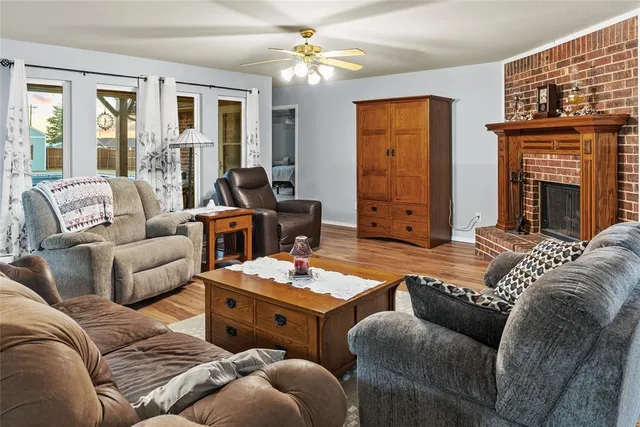 a living room with furniture ceiling fan and a fireplace