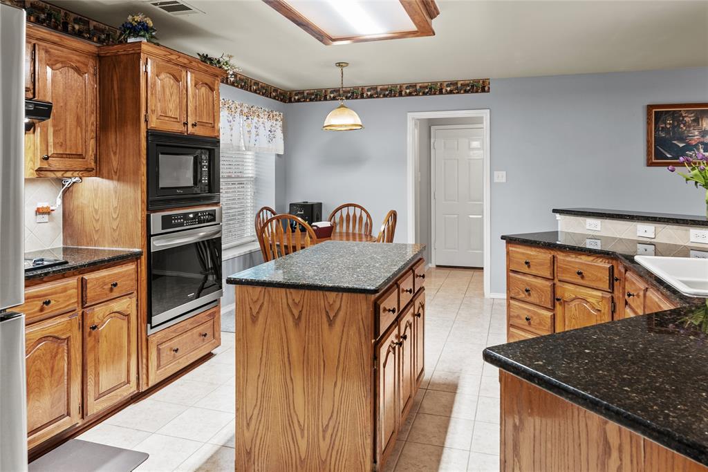 1413 Rodeo Drive Murphy, TX 75094 - Photo 5 of 29 a kitchen with stainless steel appliances granite countertop a sink a stove and a refrigerator