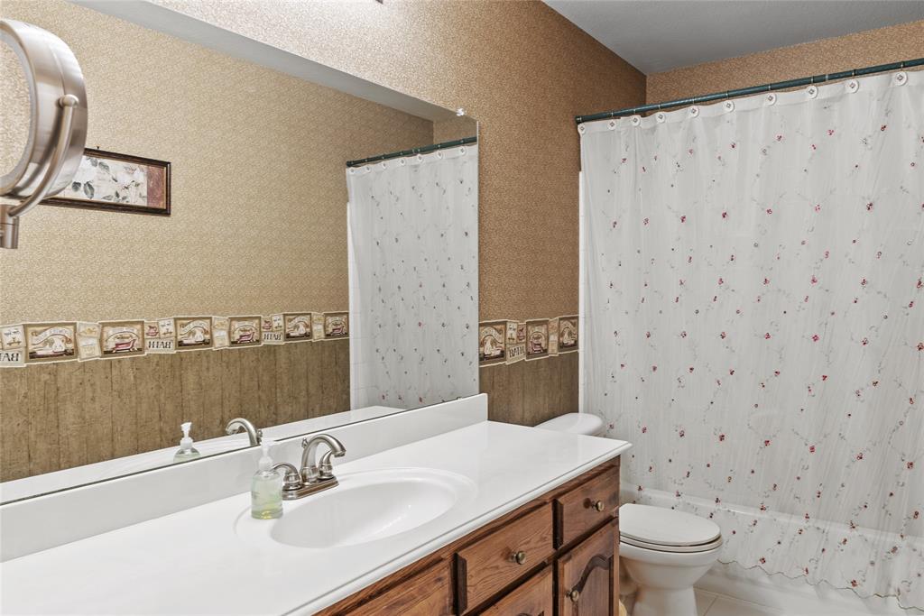 1413 Rodeo Drive Murphy, TX 75094 - Photo 10 of 29 a bathroom with a sink toilet and mirror