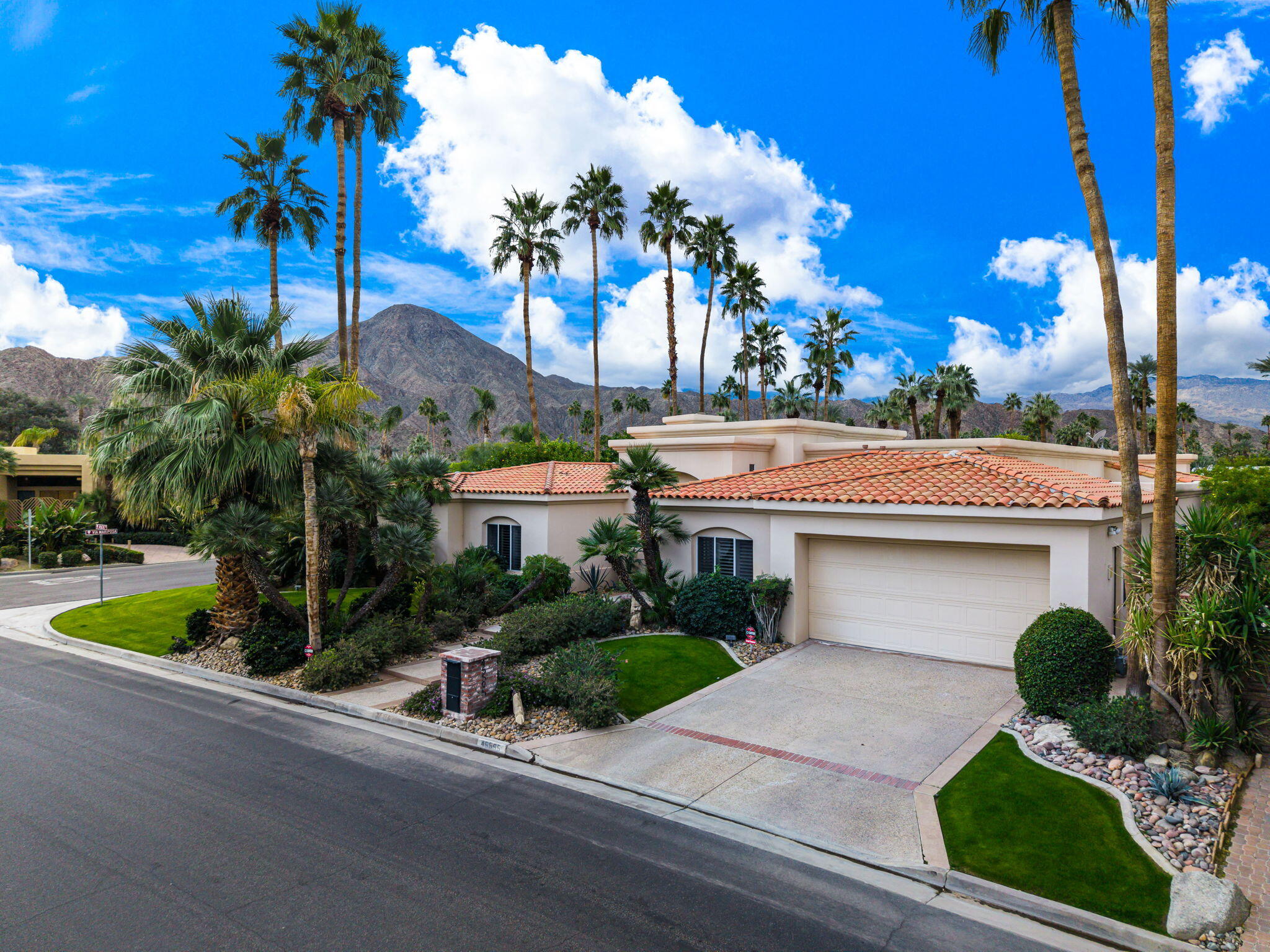 45595 Apache Road Indian Wells, CA 92210 - Photo 1 of 58 a front view of a house with garden and plants