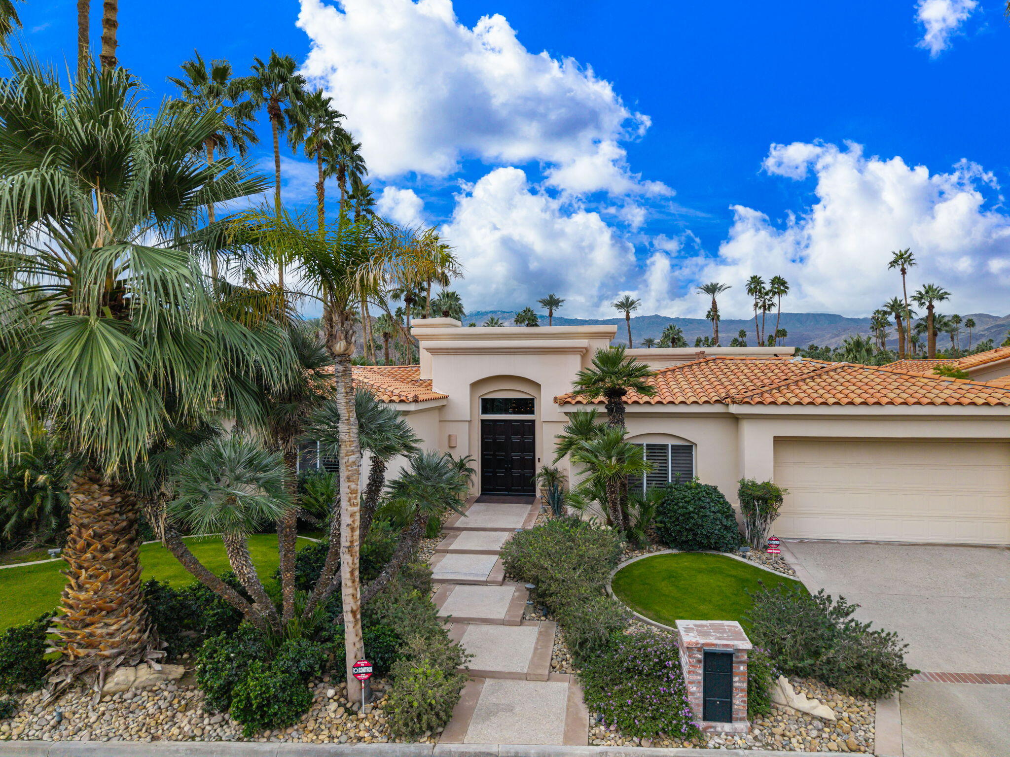 45595 Apache Road Indian Wells, CA 92210 - Photo 7 of 58 a front view of a house with a garden
