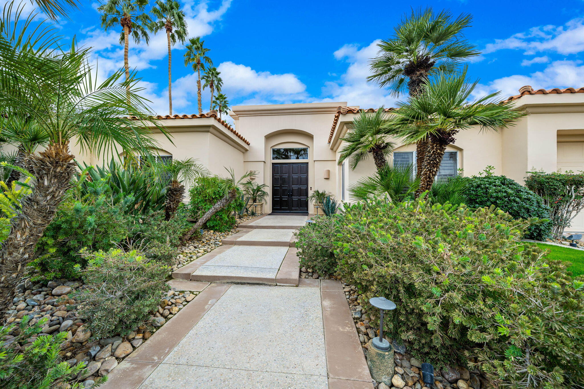 45595 Apache Road Indian Wells, CA 92210 - Photo 8 of 58 a front view of a house with a garden