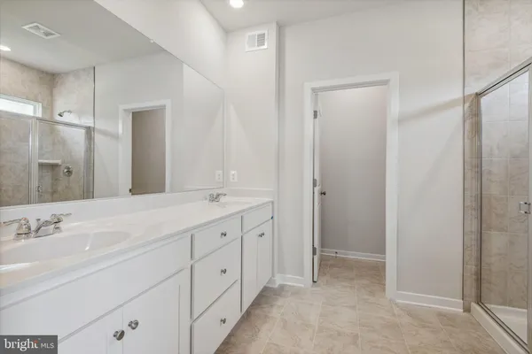 a spacious bathroom with a shower sink and mirror
