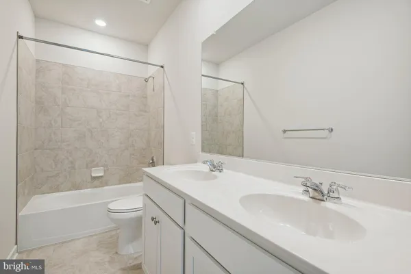 a bathroom with a granite countertop sink a toilet and shower
