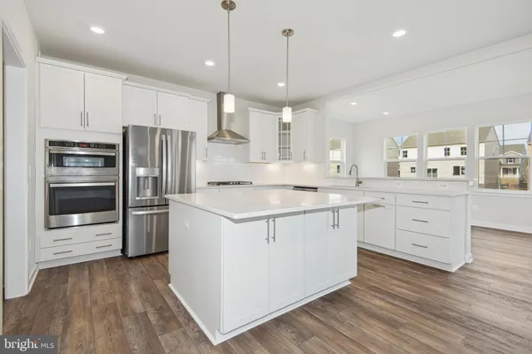 a kitchen with stainless steel appliances kitchen island granite countertop a refrigerator and a stove top oven