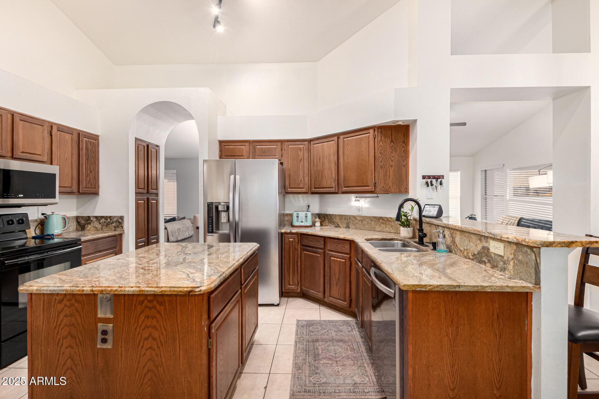 2646 North Robin Lane Mesa, AZ 85213 - Photo 13 of 45 a kitchen with stainless steel appliances granite countertop a sink a stove and a refrigerator