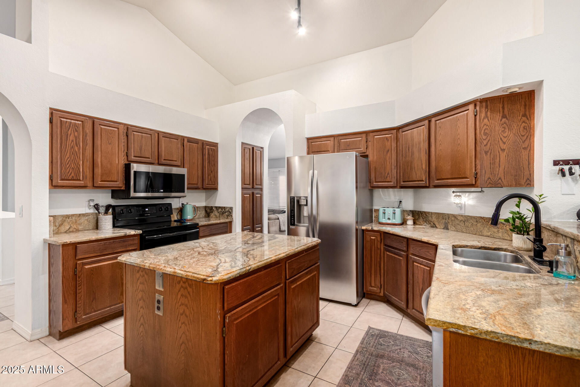 2646 North Robin Lane Mesa, AZ 85213 - Photo 14 of 45 a kitchen with stainless steel appliances granite countertop a stove refrigerator sink and microwave