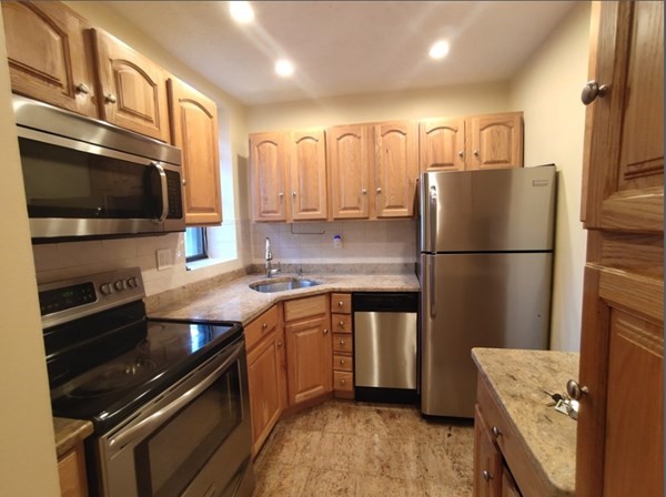 a kitchen with stainless steel appliances a refrigerator a stove a sink and a microwave