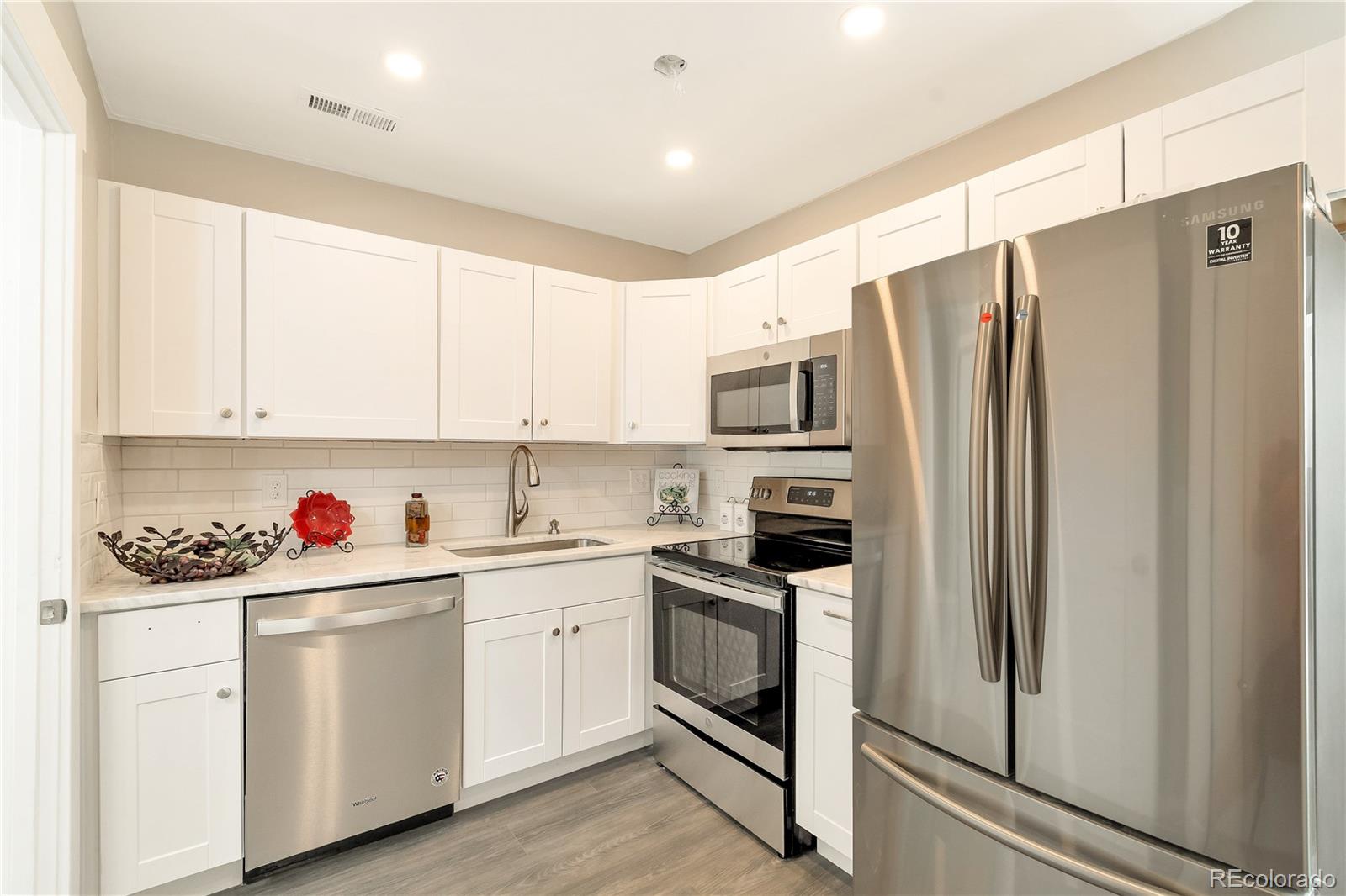 2868 Benton Street Wheat Ridge, CO 80214 - Photo 19 of 22 a kitchen with white cabinets and white appliances