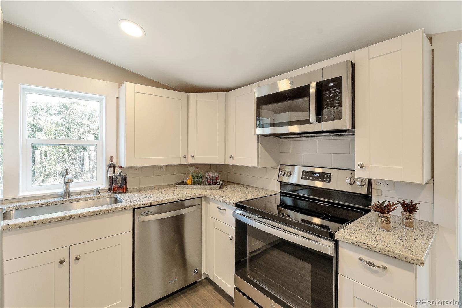 2868 Benton Street Wheat Ridge, CO 80214 - Photo 5 of 22 a kitchen with a stove microwave and sink