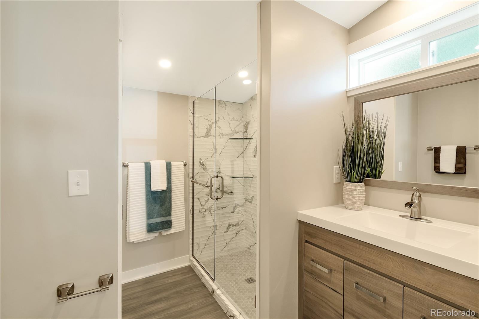 2868 Benton Street Wheat Ridge, CO 80214 - Photo 8 of 22 a bathroom with a shower sink and mirror