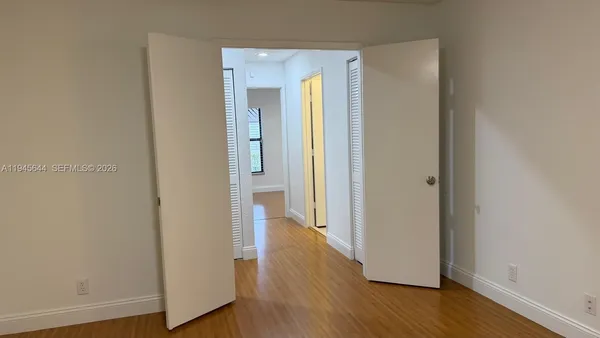 a view of a hallway with wooden floor