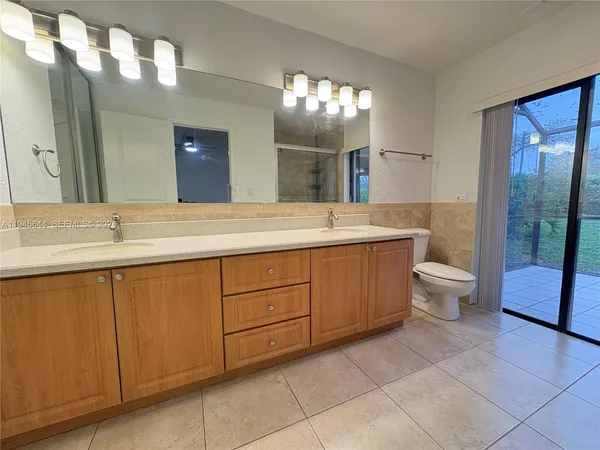 a spacious bathroom with a double vanity sink toilet and a mirror