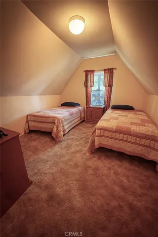 a bedroom with two beds and window