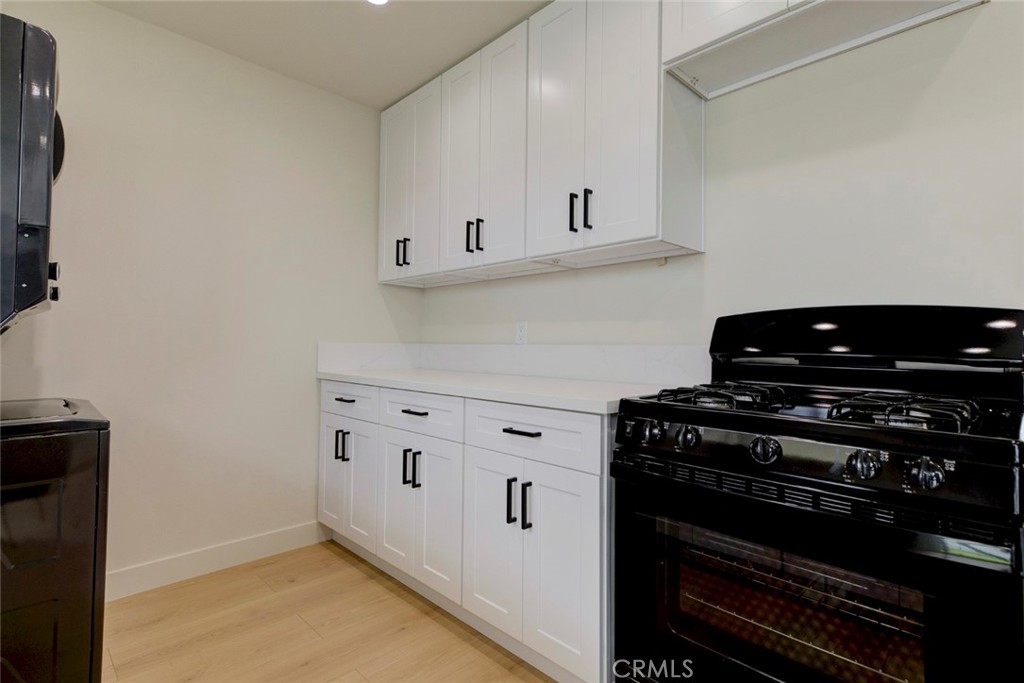 9917 Marcus Avenue, Unit 9917 Tujunga, CA 91042 - Photo 14 of 32 a kitchen with white cabinets and appliances