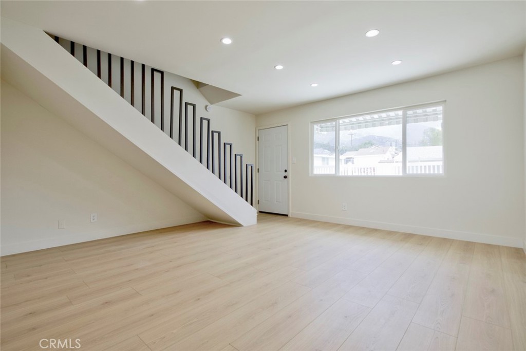 9917 Marcus Avenue, Unit 9917 Tujunga, CA 91042 - Photo 4 of 32 an empty room with wooden floor and windows