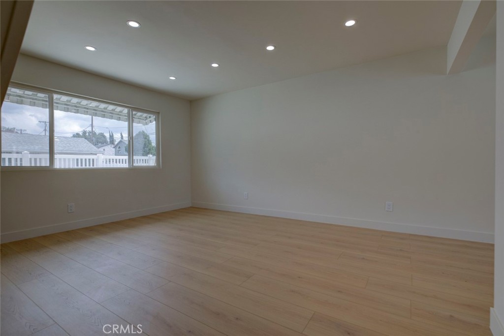 9917 Marcus Avenue, Unit 9917 Tujunga, CA 91042 - Photo 7 of 32 an empty room with wooden floor and windows