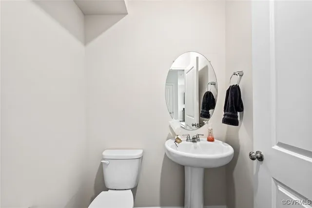 a bathroom with a sink mirror and toilet
