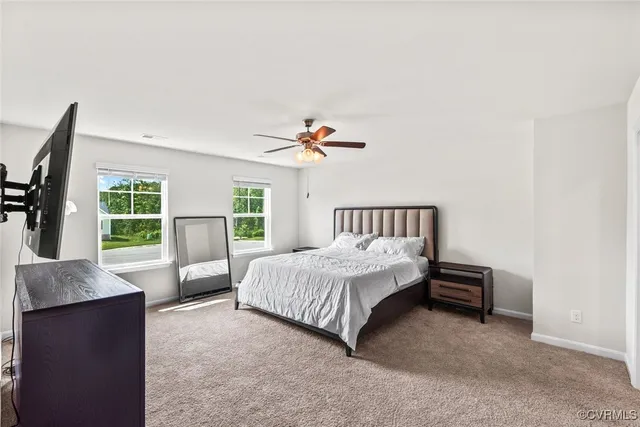 a bedroom with a bed couch and a flat tv screen