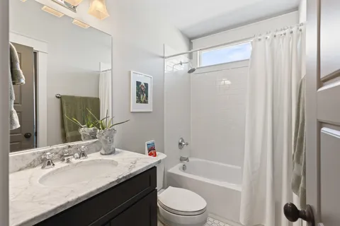 a bathroom with a granite countertop sink toilet and shower