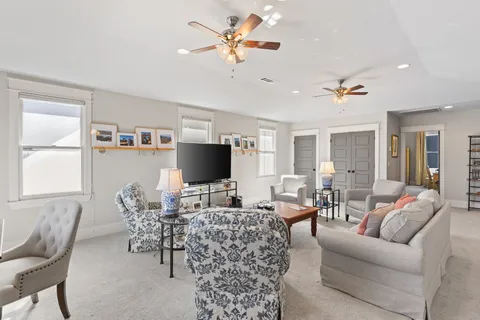 a living room with furniture a chandelier and a flat screen tv