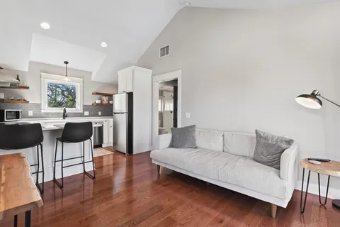 a living room with furniture and a dining table with kitchen view