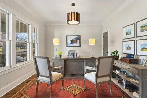 a view of a dining room with furniture a chandelier and wooden floor