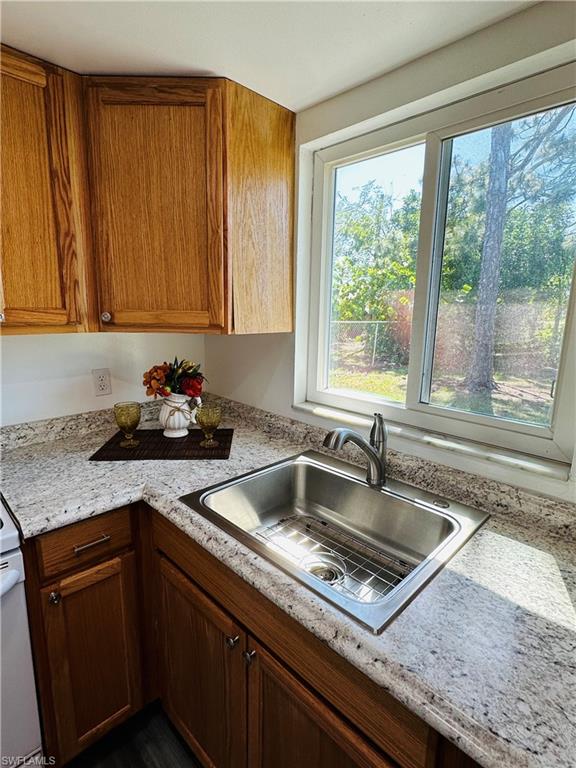 19040 Tampa Road South Fort Myers, FL 33967 - Photo 16 of 23 a kitchen with granite countertop a sink window and cabinets