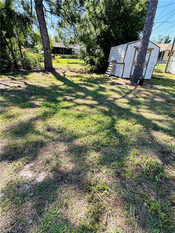 19040 Tampa Road South Fort Myers, FL 33967 - Photo 19 of 23 a view of swimming pool with a yard and large trees