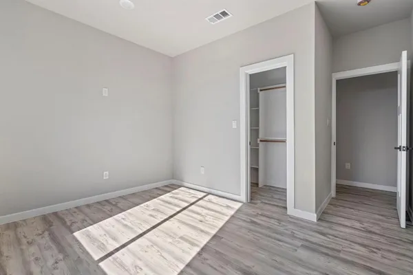 an empty room with a hardwood and ceiling fan