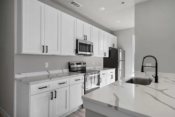 a kitchen with a sink cabinets and wooden floor