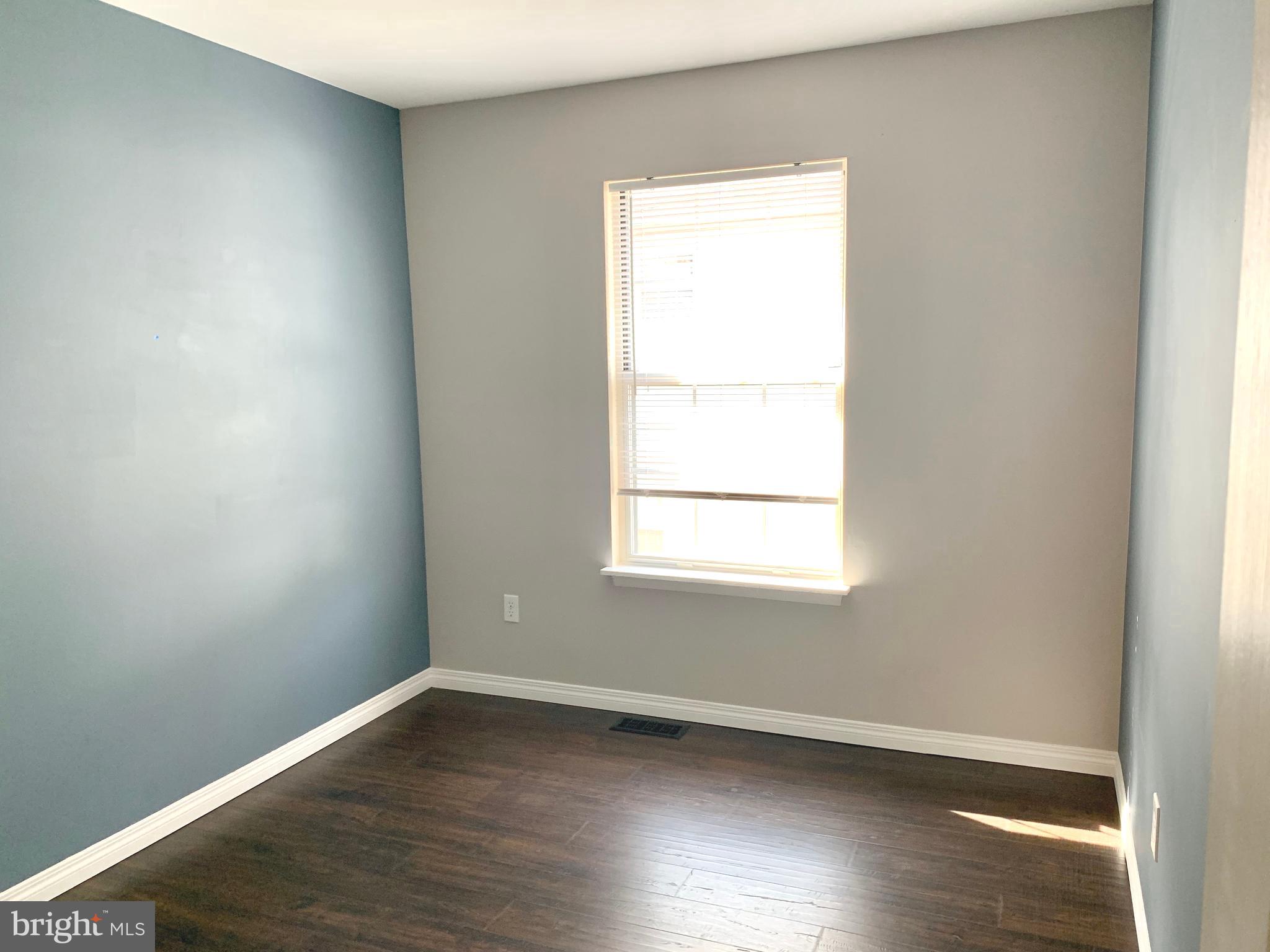 808 207th Street Pasadena, MD 21122 - Photo 13 of 20 an empty room with wooden floor and a window