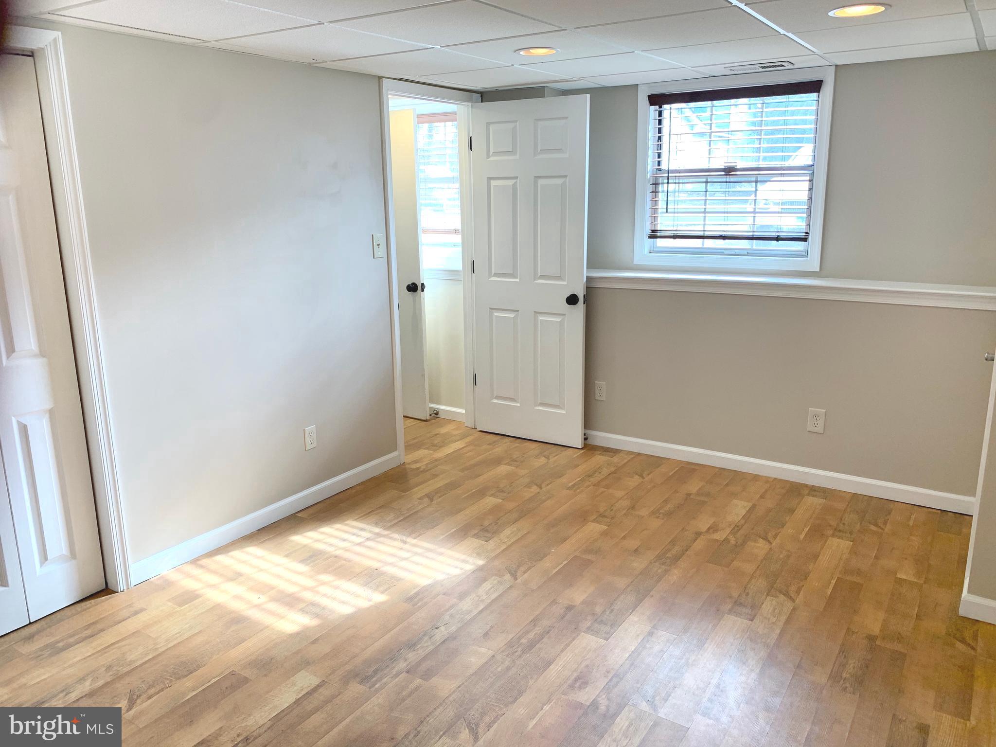 808 207th Street Pasadena, MD 21122 - Photo 17 of 20 an empty room with wooden floor and windows